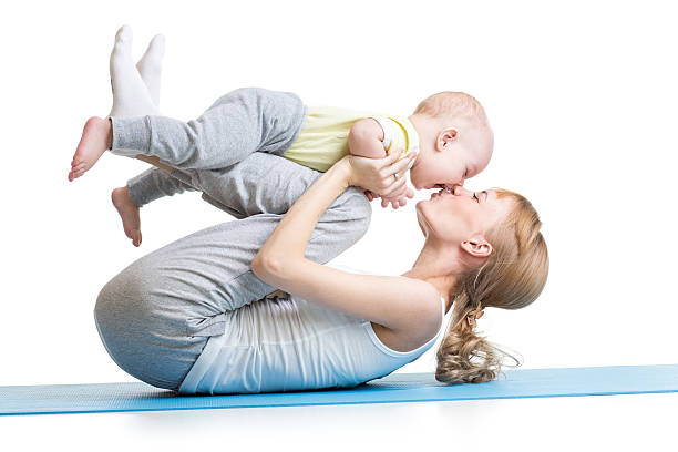 young mother does fitness exercises together with kid boy stock photo