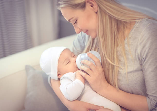 그녀의 작은 소중한 아기 먹이 젊은 어머니 - baby formula 뉴스 사진 이미지