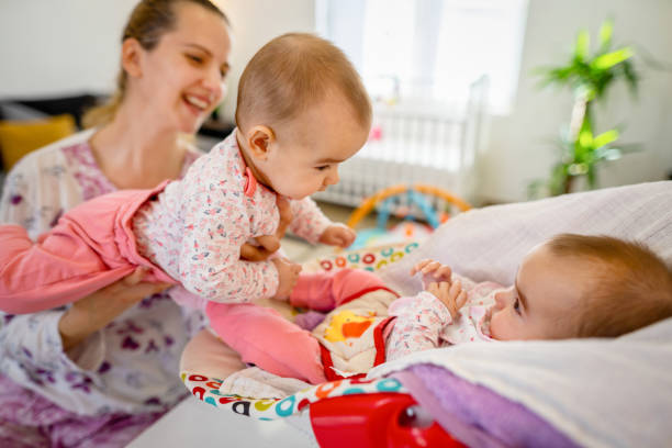 Young mother playing with her newborn babies Young mother playing with her newborn babies tickling beautiful women pictures stock pictures, royalty-free photos & images