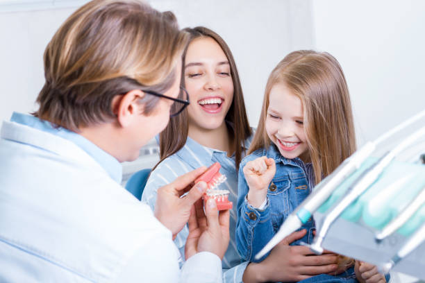 Young mother with daughter at dentist office stock photo