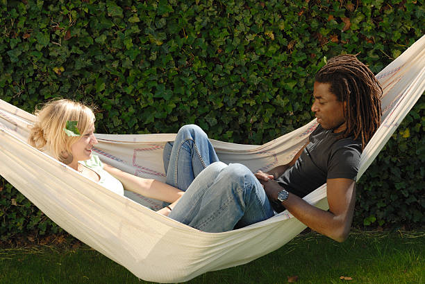 young multi-ethnic couple in hammock stock photo