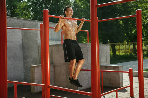 The image of a man doing a wide-grip pull-up
