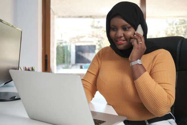 Young muslim woman calling while working from home office. stock photo