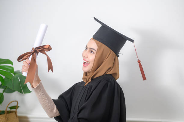 Young muslim woman graduated holding a certification. A young muslim woman graduated holding a certification. Religious studies degree stock pictures, royalty-free photos & images