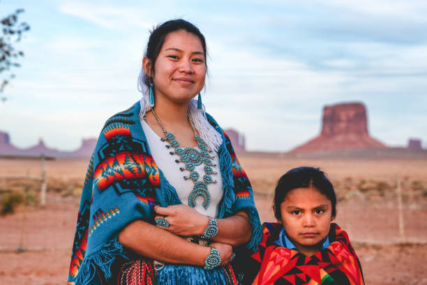 A Young Navajo Brother and Sister Who Live In Monument Valley, Arizona Native American sister and little brother posing for photographs in their native costumes navajo culture stock pictures, royalty-free photos & images