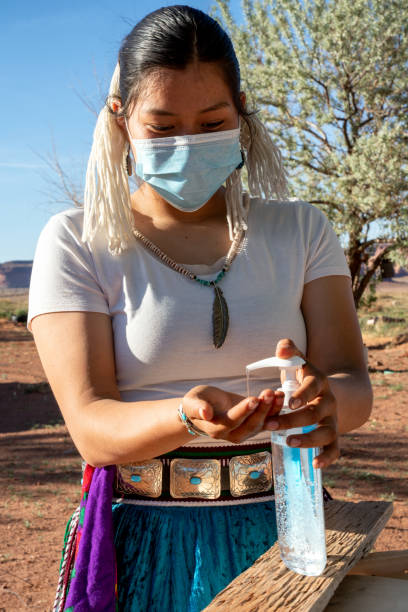A Young Navajo Teenager Applying Hand Sanitizer To Help Protect Her From Coronavirus A teenage Navajo girl is putting a hand sanitizer on to protect her from Covid19 navajo nation covid stock pictures, royalty-free photos & images