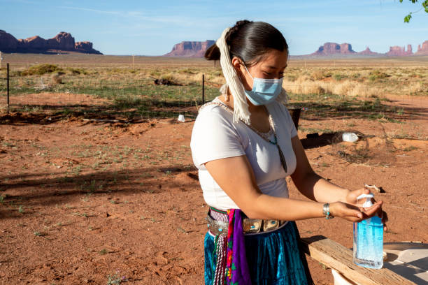 A Young Navajo Teenager Applying Hand Sanitizer To Help Protect Her From Coronavirus A teenage Navajo girl is putting a hand sanitizer on to protect her from Covid19 navajo nation covid stock pictures, royalty-free photos & images
