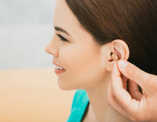 인트라 이어 보청기와 젊은 환자, 여성의 귀에 클로즈업. 보청기, 청각학자 삽입 보청기 - hearing aids 뉴스 사진 이미지