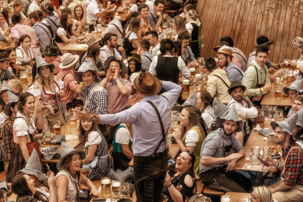 jugendliche feiern in bier pavillon auf oktoberfestfest in münchen - oktoberfest stock-fotos und bilder
