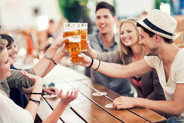 Young people drinking beer outdoors stock photo