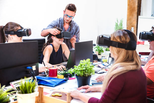 Young people employee workers having fun with vr virtual reality goggles in startup studio - Human resource business concept on milenials working time - Start up entrepreneur at office - Bright filter stock photo