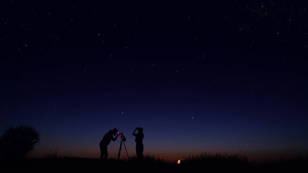 young people observing the night sky - céu olhar estrelas imagens e fotografias de stock