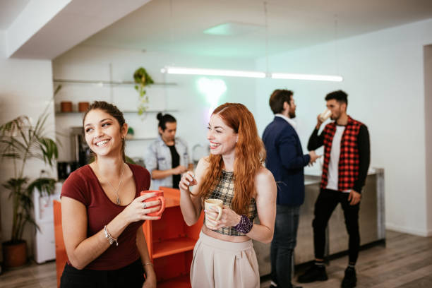 Young people re-unite in cafe after lockdown Group of coworkers coming back to work after lockdown coffee break stock pictures, royalty-free photos & images