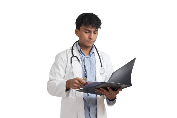 Young peruvian male doctor reading a medical report on a folder, isolated. stock photo