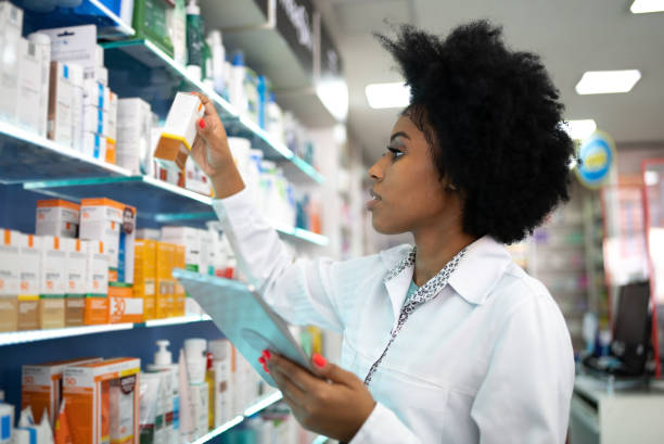 Young pharmacist checking the shelves with a digital tablet at the pharmacy Young pharmacist checking the shelves with a digital tablet at the pharmacy generic drug stock pictures, royalty-free photos & images