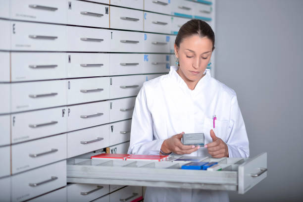 Young pharmacist woman looking for medicine stock photo