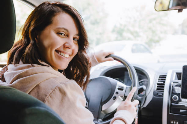 young pretty driver woman sitting in car stock photo