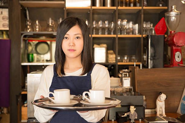 Young Pretty Waitress at  Japanese cafe restrant in Tokyo Young Pretty Waitress is serving coffee at the Japanese cafe restrant in Tokyo cafe culture stock pictures, royalty-free photos & images