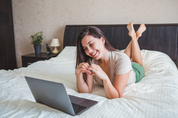 young pretty woman talking by video chat on laptop. online dating stock photo