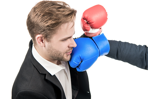 Young professional business man get punched in face with boxing glove isolated on white, looser.