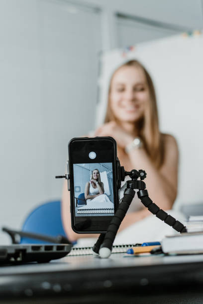 young professional businesswoman vlogger coach talking to camera. female blogger recording video. filming live video blog or vlog, giving business class presentation, training teaching people online. - smartphone filming imagens e fotografias de stock