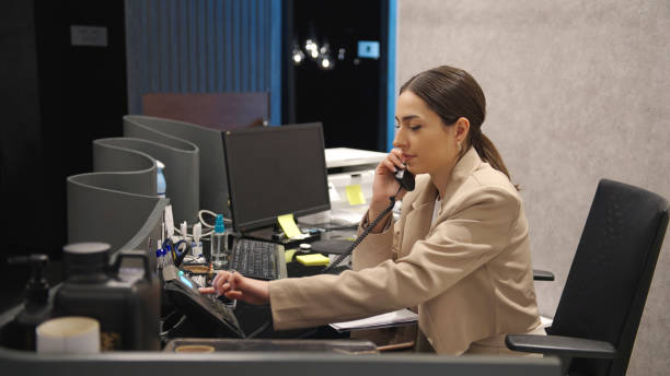 Young receptionist using a landline phone stock photo