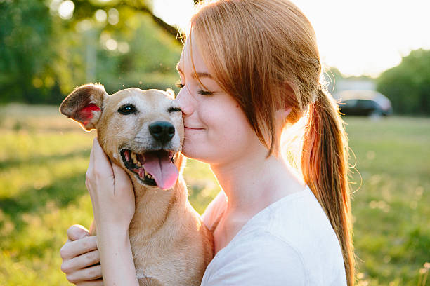 young redhead woman hug her small Mixed-breed dog stock photo