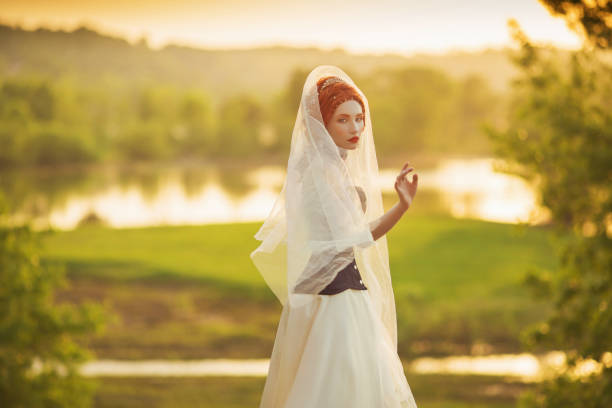 Young renaissance princess on veil on nature background. Virgin woman. Rococo queen in white dress against backdrop of sunset. Princess in veil dress. Renaissance imitation of countess. Edwardian look  victorian gown stock pictures, royalty-free photos & images