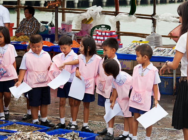 Young school children visiting fish market in Ang Sila stock photo