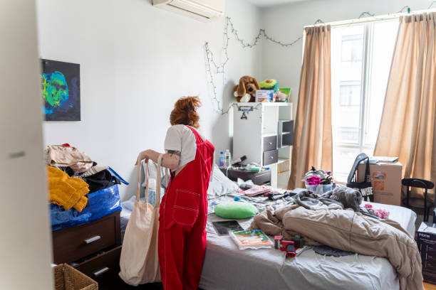 Young slender woman is packing her stuff preparing to move to a new apartment stock photo