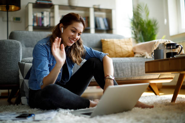 Young smiling woman having video call on laptop computer at home stock photo