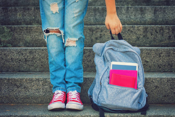 Young Student Girl With Backpack Young student girl with backpack staying on the stairs - back to school concept backpack stock pictures, royalty-free photos & images