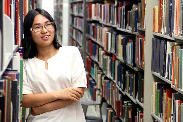Young Student Looking for a Book in the Library stock photo