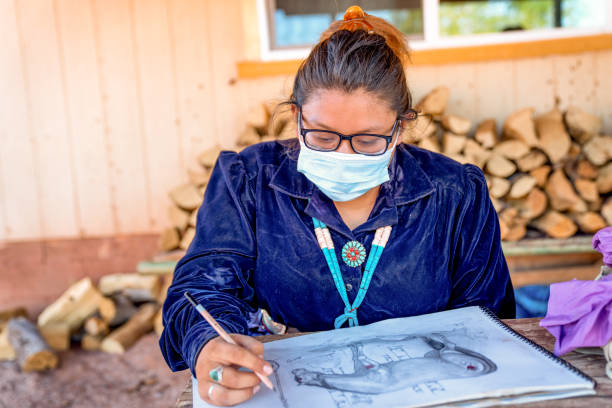 Young Teenage Navajo Girl Drawing a Picture while Wearing a Covi-19 Mask Young Teenage Navajo Girl Drawing a Picture while Wearing a Covi-19 Mask navajo nation covid stock pictures, royalty-free photos & images