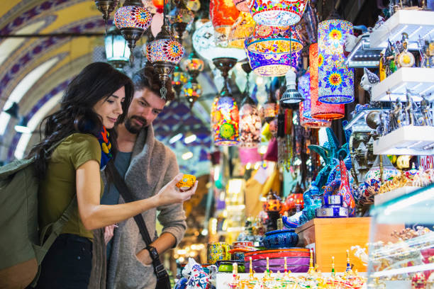 jonge toeristische paar winkelen in de grand bazaar, istanbul, turkije - kraamcadeau stockfoto's en -beelden