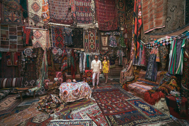 unga turister njuter på traditionell matta butik i kappadokien, turkiet - basar marknadsplats bildbanksfoton och bilder