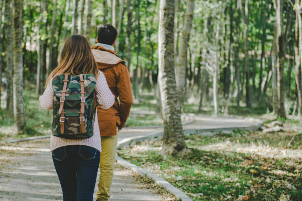 Young trendy couple walking in the woods stock photo