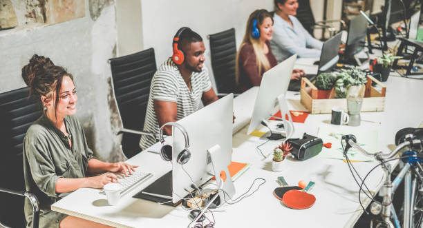 Young trendy teamwork using computer in creative coworking office - Business people working together at new app project - Focus on left woman face - Technology, influencer, marketing and job concept Young trendy teamwork using computer in creative coworking office - Business people working together at new app project - Focus on left woman face - Technology, influencer, marketing and job concept Internet Marketer stock pictures, royalty-free photos & images