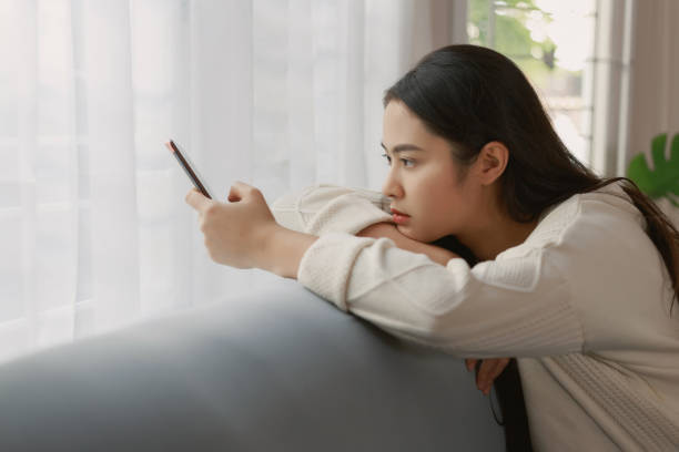 12 Indoor Sad Asian Girl Holding Her Head And Mobile Phone Stock Photos,  Pictures & Royalty-Free Images - iStock