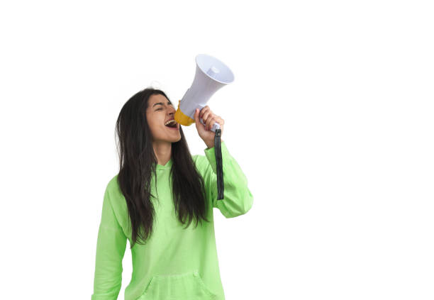 Young Venezuelan woman shouting through megaphone, isolated. stock photo