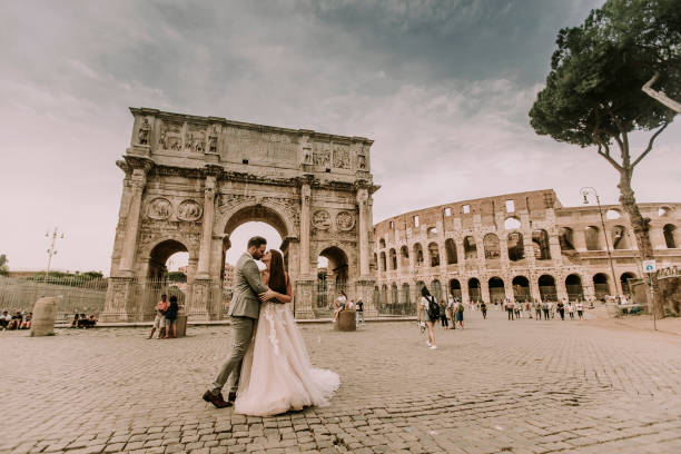 Young wedding couple by Arch of Constantine in Rome stock photo