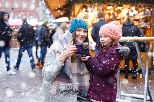 jonge vrouw en schattige jongen meisje met een kopje warme chocolademelk of kinderen stomen punch - berlin snow stockfoto's en -beelden