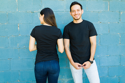 Good-looking couple wearing matching black t-shirts with a beautiful design in the front and back