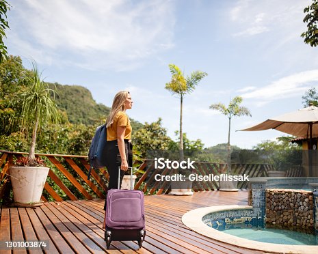 istock Young woman arriving at a tropical resort for her vacation 1301003874