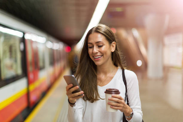 Young woman at subway station Woman using mobile phone at subway station underground stock pictures, royalty-free photos & images