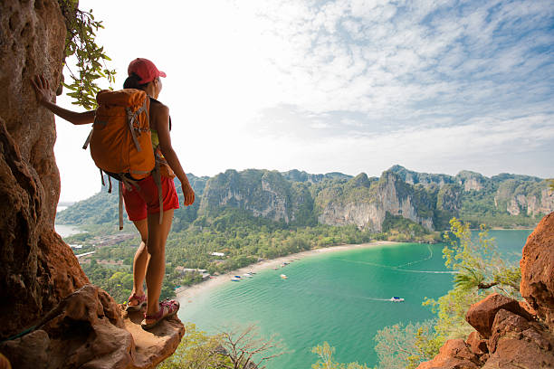 young woman backpacker hiking on seaside mountain - adventure woman stockfoto's en -beelden