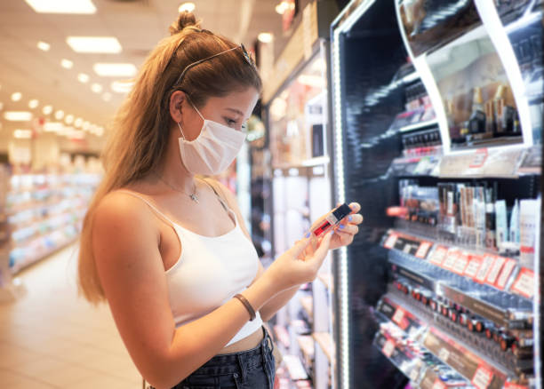 Young Woman buying  beauty product during pandemic with face mask Young Woman buying  beauty product during pandemic with face mask safety of cosmetics stock pictures, royalty-free photos & images