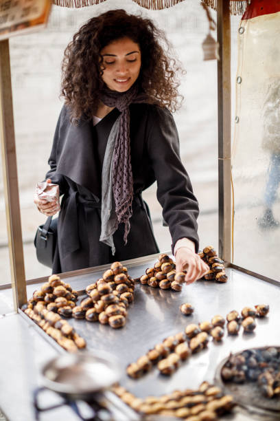 Young woman buying chestnuts in Istanbul, Turkey Young woman buying chestnuts in Istanbul, Turkey hot arab woman stock pictures, royalty-free photos & images