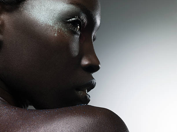Young woman covered in metallic make up black skin stock pictures, royalty-free photos & images