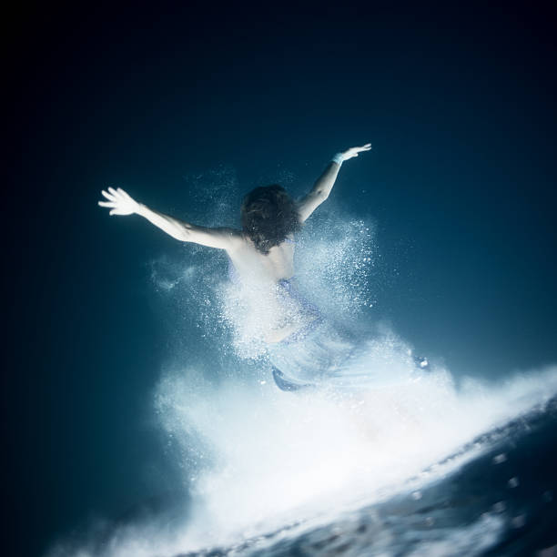 Young woman dive into deep water stock photo